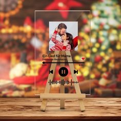 a wooden easel with an image of a man and woman on it, in front of a christmas display