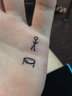 a person's hand with a small tattoo on it