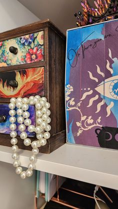 two drawers with beads and other items on top of the shelf next to each other