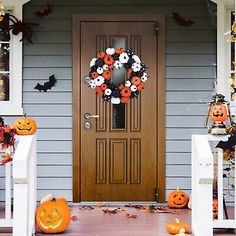 a front porch decorated for halloween with pumpkins and decorations