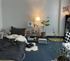 a bed room with a neatly made bed next to a book shelf and a lamp