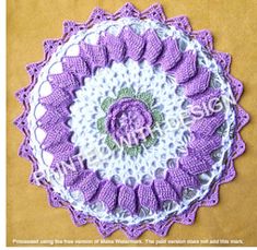 a crocheted doily is shown in purple and white