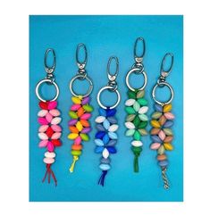 six key chains with different colored beads hanging from each one's side on a blue background