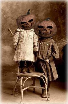 an old black and white photo of two children dressed up as pumpkins