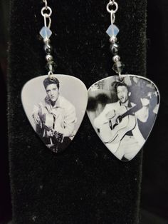 two guitar picks with pictures on them hanging from chains