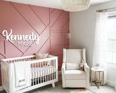 a baby's room with pink walls and white furniture