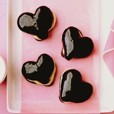 four heart shaped cookies sitting on top of a table