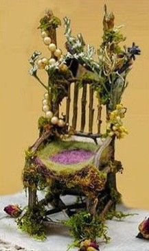 a chair made out of flowers and plants sitting on top of a white table cloth