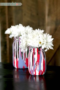 two red, white and blue vases with flowers in them