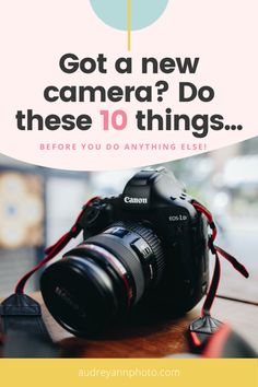 a camera sitting on top of a wooden table next to a sign that says, got a new camera? do these 10 things before you do anything else