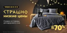 a black cat sitting on top of a bed next to a night stand with lights