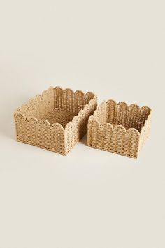 two woven baskets sitting side by side on a white surface, one is empty and the other has no lid