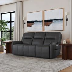 a living room scene with focus on the reclining sofa and two large paintings above it