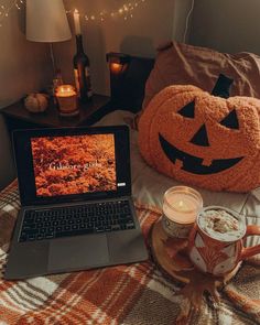 an open laptop computer sitting on top of a bed next to a cup of coffee