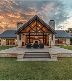 a house that is sitting in the grass with stairs leading up to it's front door