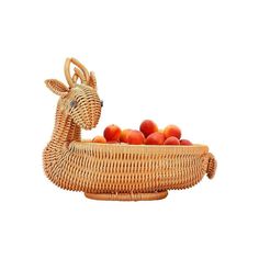 a wicker basket with apples in it and a deer figurine next to it