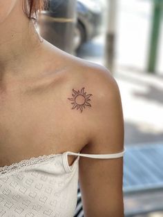 a woman with a small sun tattoo on her shoulder