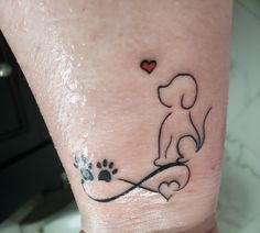 a dog paw and heart tattoo on the left ankle, with an outline of a dog's paw