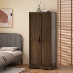 a bed sitting next to a tall wooden cabinet in a room with beige walls and wood flooring