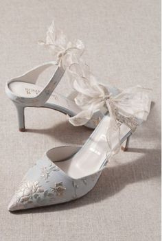 a pair of wedding shoes with bows on the toes and heels are shown in light blue