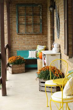 an outdoor patio with yellow chairs and flowers