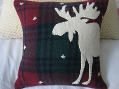 two pillows with moose and snowflakes on them, one is red and the other is green