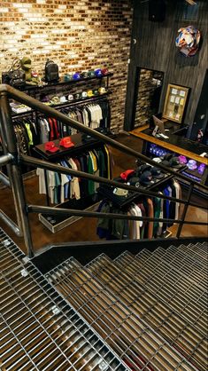 an escalator in a clothing store filled with lots of shirts and ties on racks