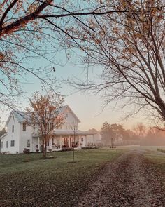 a large white house sitting on top of a lush green field