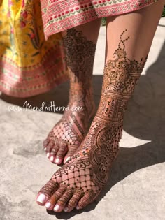 the feet and legs of a woman with henna tattoos