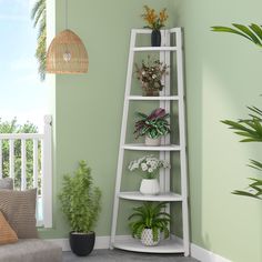 a living room with green walls and potted plants on the corner shelf next to a couch