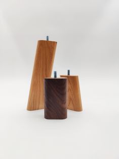 three wooden objects sitting next to each other on a white surface