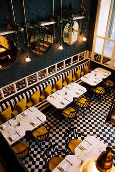 an empty restaurant with checkered tables and yellow chairs