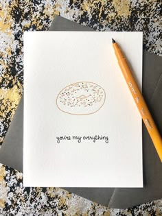 a card with a donut drawn on it next to a pencil and paper that says, you're my everything