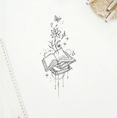 an open book sitting on top of a table next to a pen and pencils