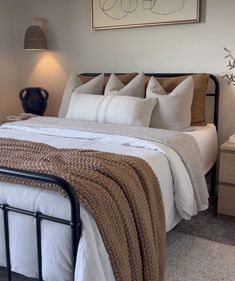 a bed with white sheets and pillows in a bedroom