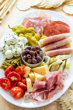 a white plate topped with lots of different types of meats and veggies