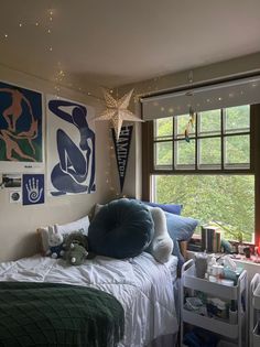 a bedroom with two beds and pictures on the wall above them, along with toys