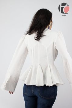 the back of a woman's white blouse with ruffles and long sleeves