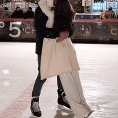 a man and woman are kissing on an ice rink