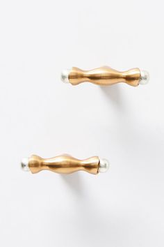 two gold and silver handles on white wall