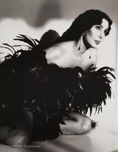 a black and white photo of a woman with feathers on her body