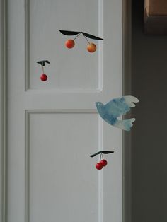 the door is painted white and has cherries hanging from it