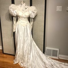 a white wedding dress on display in a room