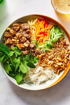 a bowl filled with noodles, meat and veggies