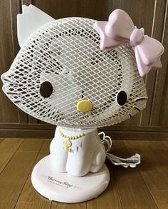 a hello kitty figurine is sitting on top of a coffee cup holder in the shape of a cat