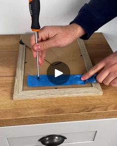 a person is using a screwdriver to fix a hole in a piece of wood