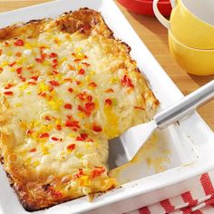 a square casserole dish with red and yellow condiments on the side