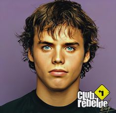 a young man with blue eyes and curly hair looks at the camera while wearing a black t - shirt