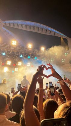 people are taking pictures with their cell phones at a concert