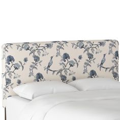 an upholstered headboard with blue flowers and birds on it